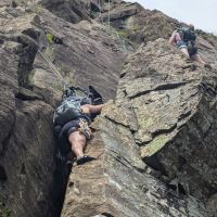 Caroline pushes the heaviest rucksack in the world up Harrow Buttress. Much swearing. (Harry Potts)